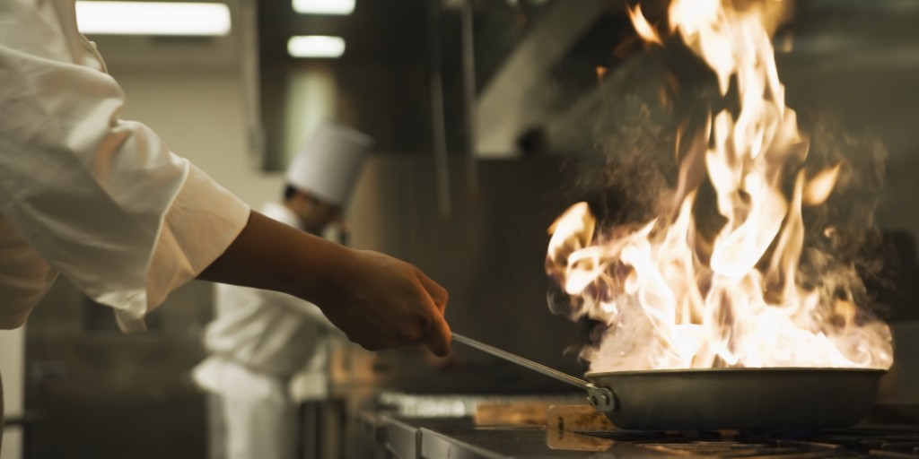 Chef holding flaming pan
